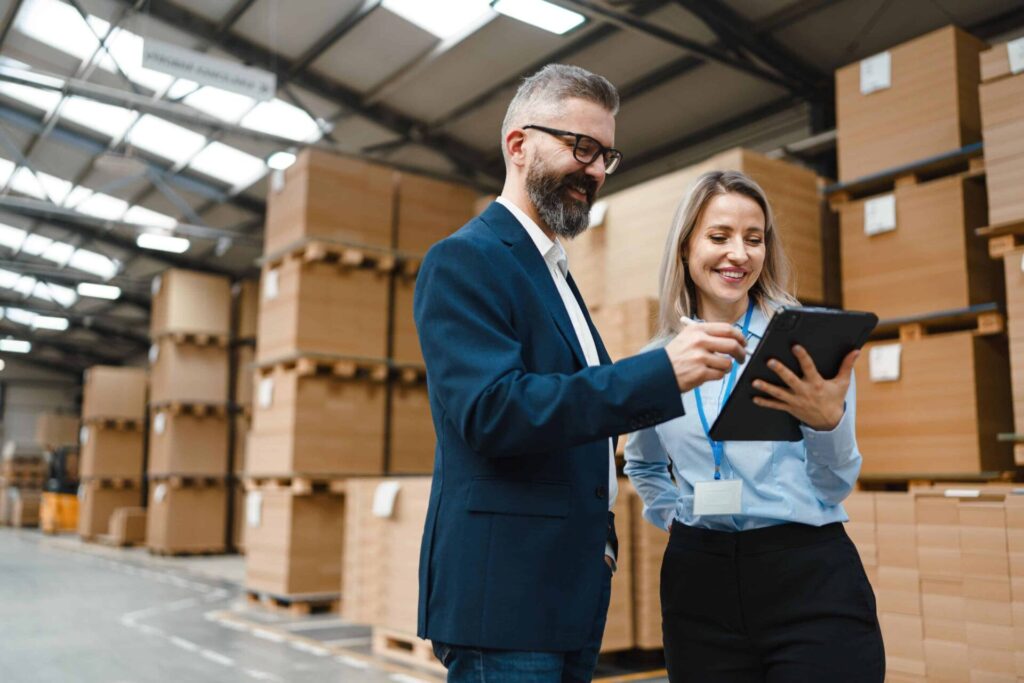 Two professionals reviewing data in a warehouse.