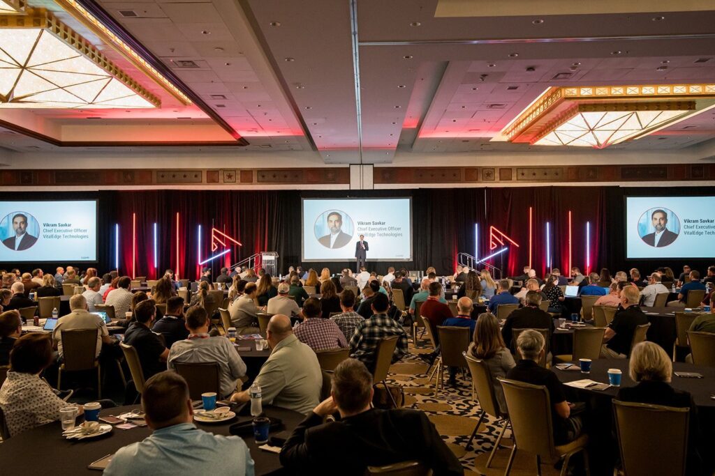 Conference speaker presenting to a large audience.