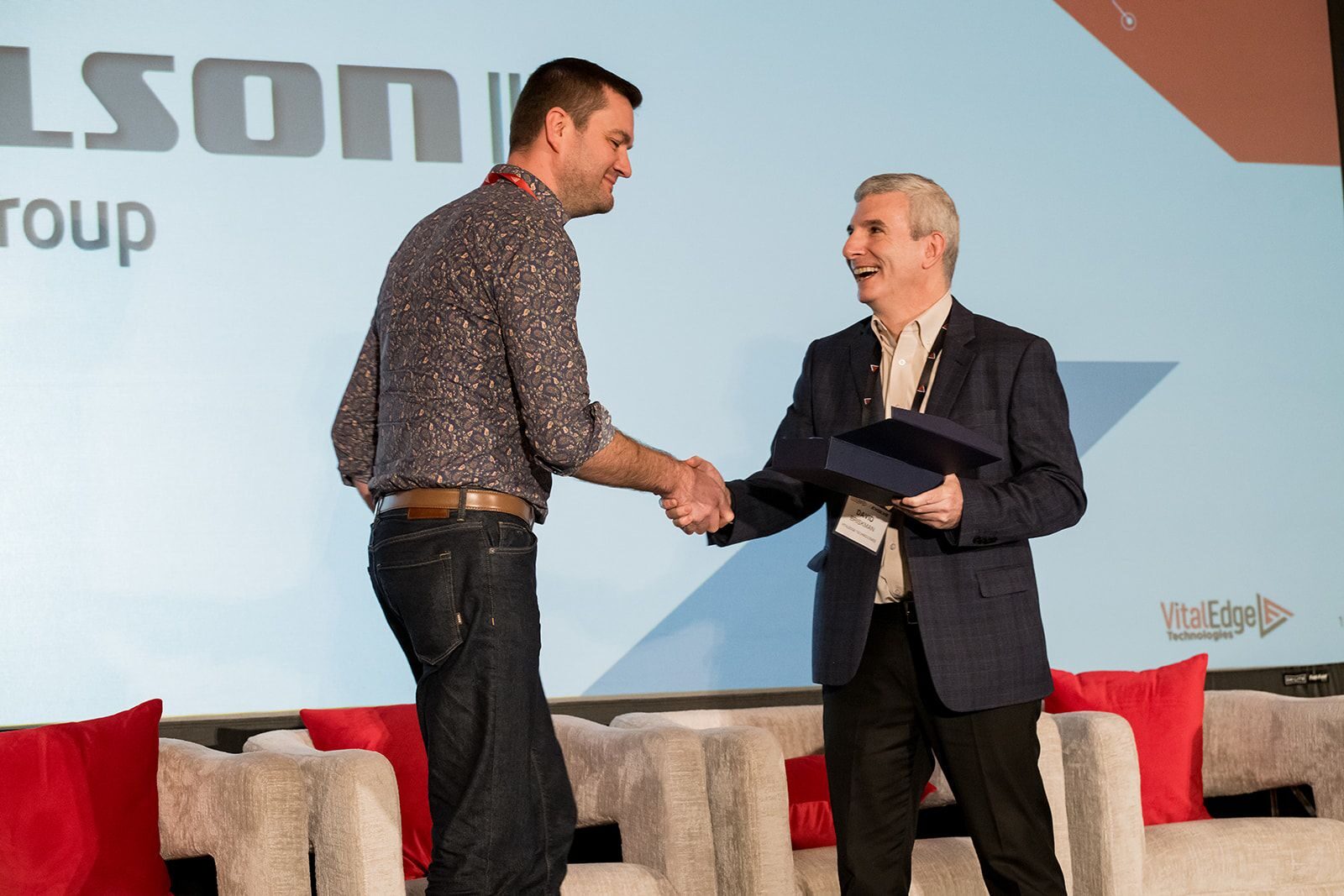 Two men shaking hands at a conference.