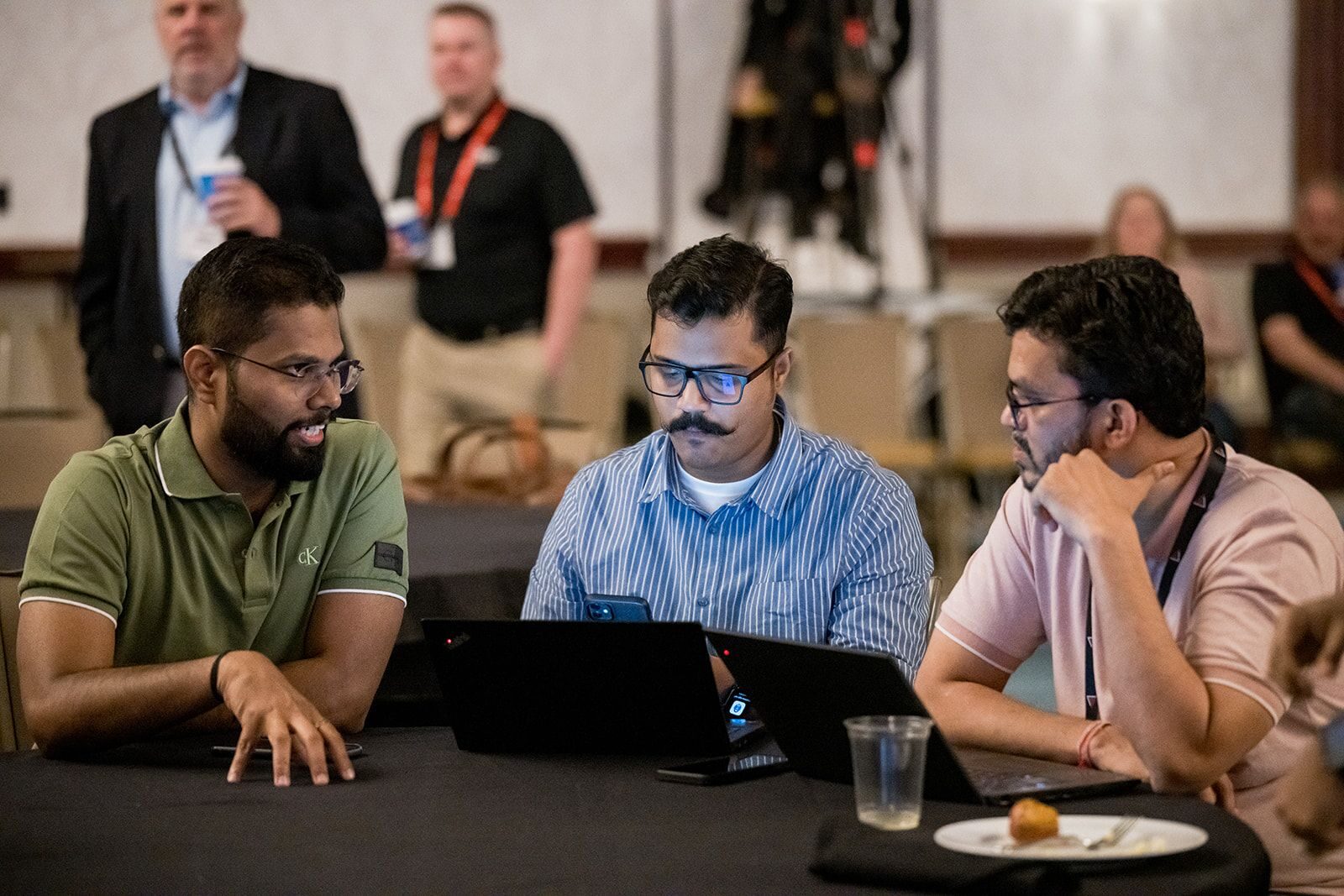 Group discussing over laptops at a conference table.