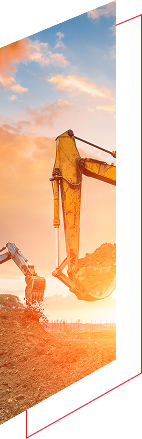 Excavator digging soil at sunset