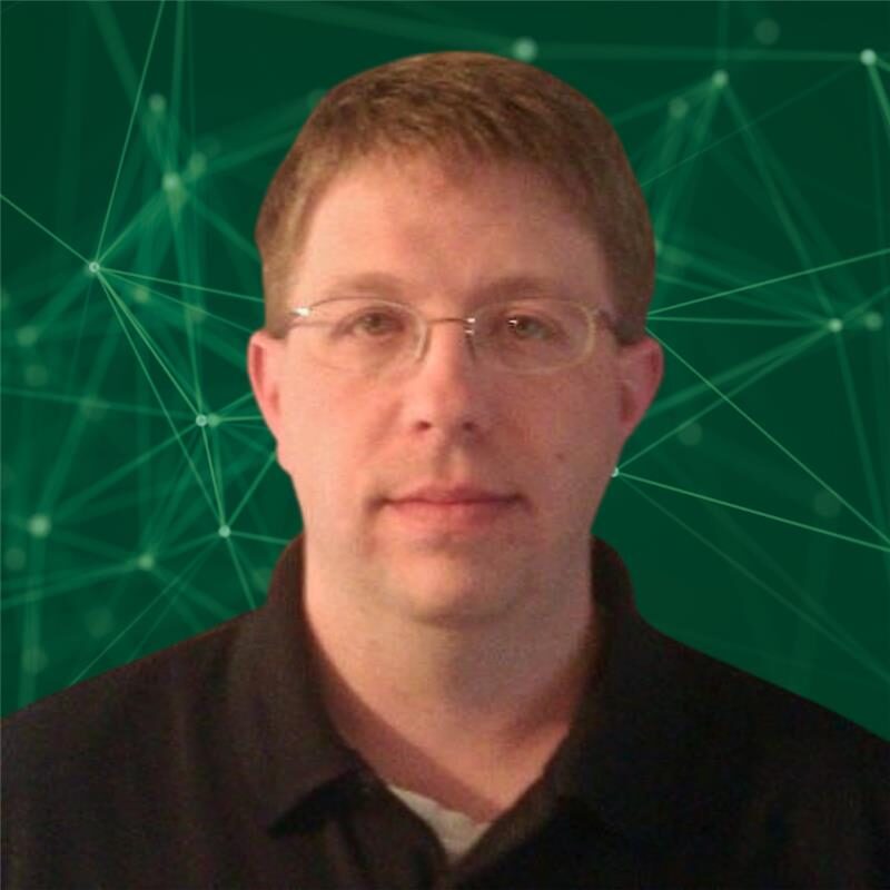 Man with glasses and short hair on a green background.