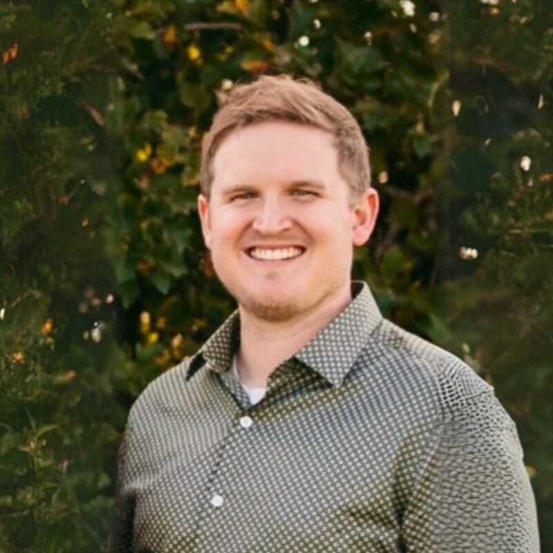 Smiling man in patterned shirt outdoors